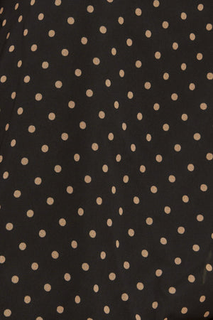 A woven dotted top featuring front bow tie and capelet.