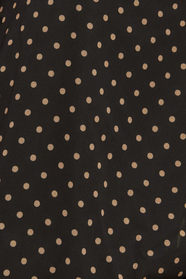 A woven dotted top featuring front bow tie and capelet.