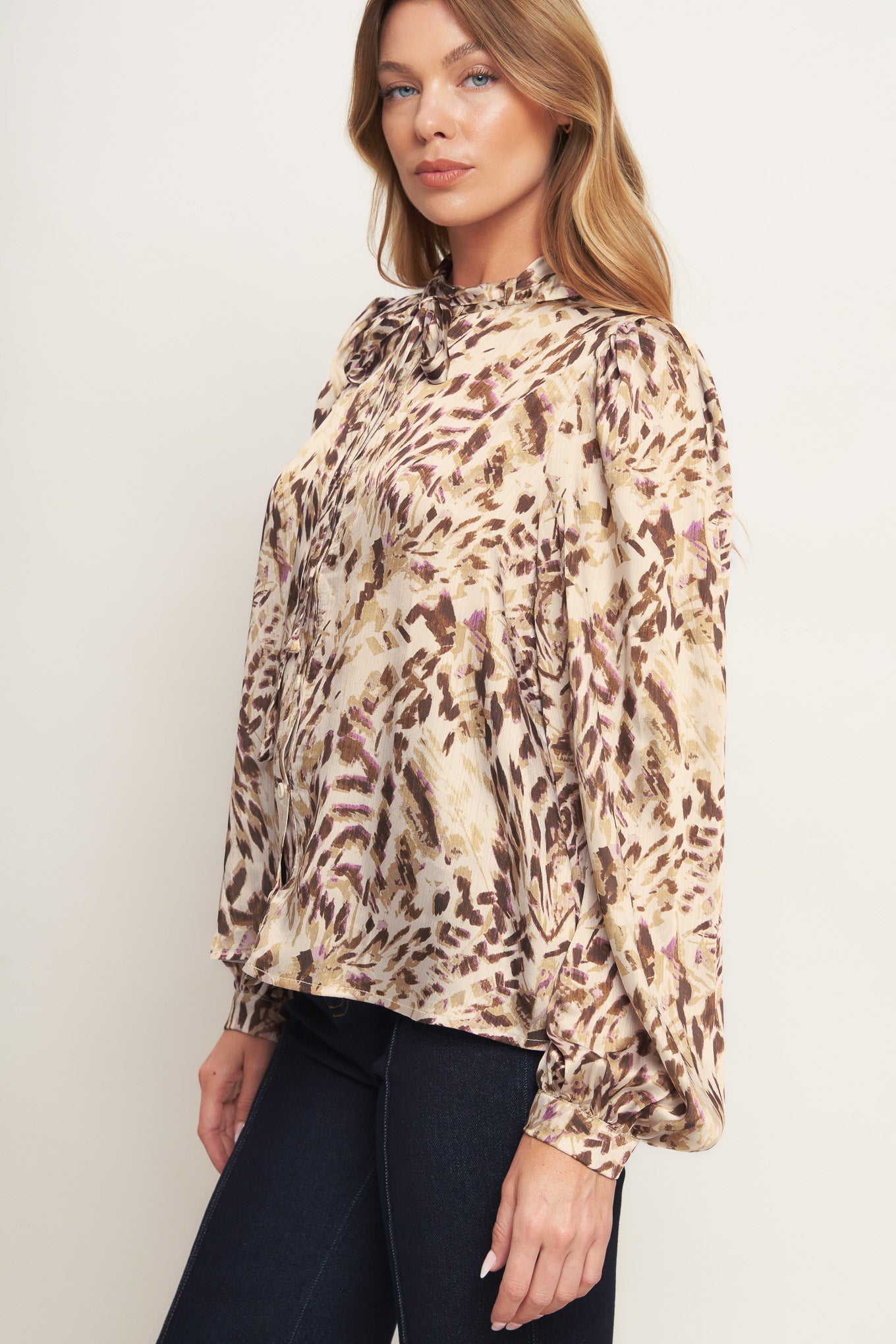 A printed woven top featuring round neckline with skinny tie, button down and long blouson sleeve