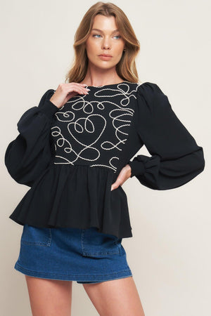 A solid woven top featuring round neckline, long sleeve, embellished bodice, peplum and back zipper closure