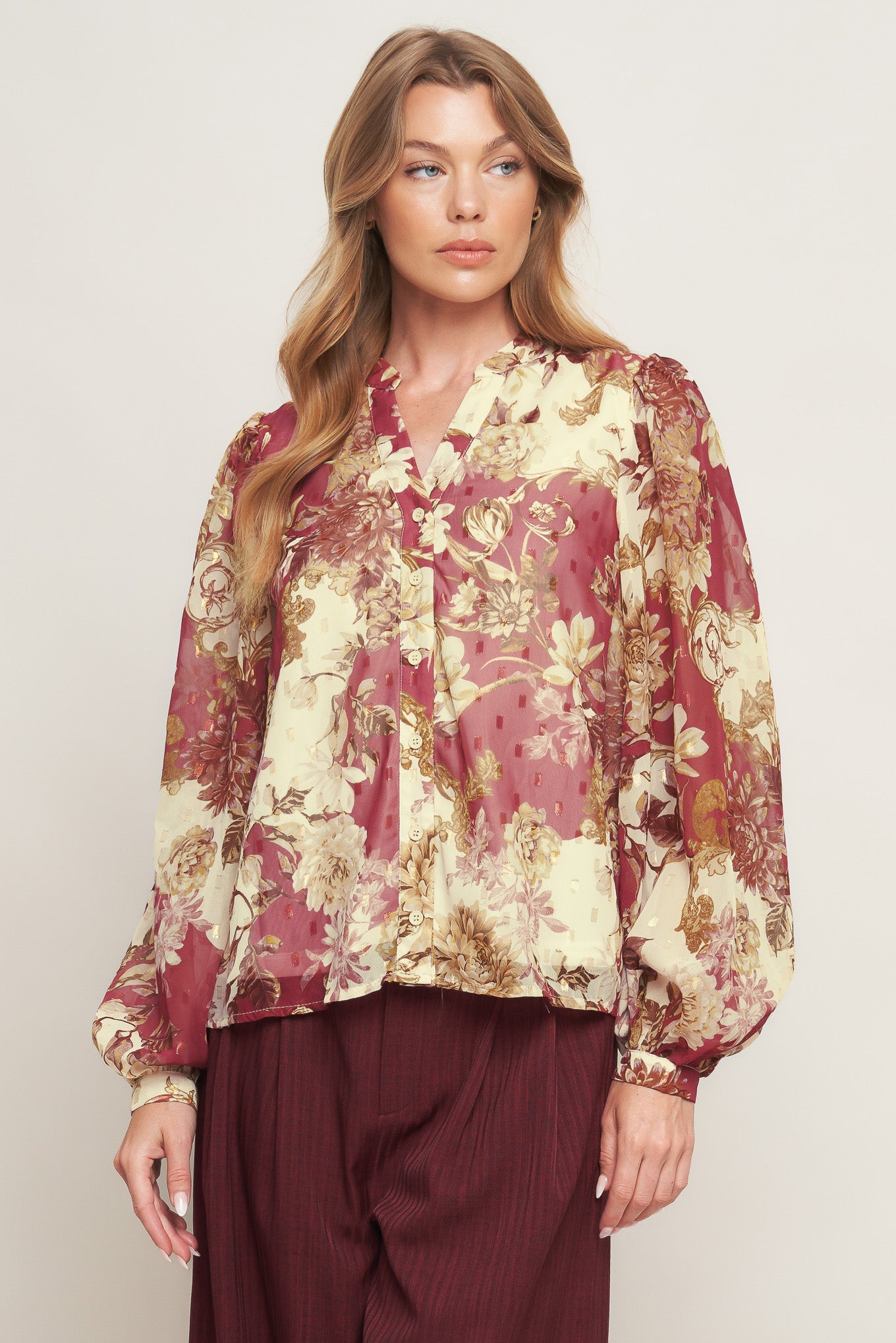 A printed woven top featuring round neckline with V front, long sleeve with cuff and button down closure