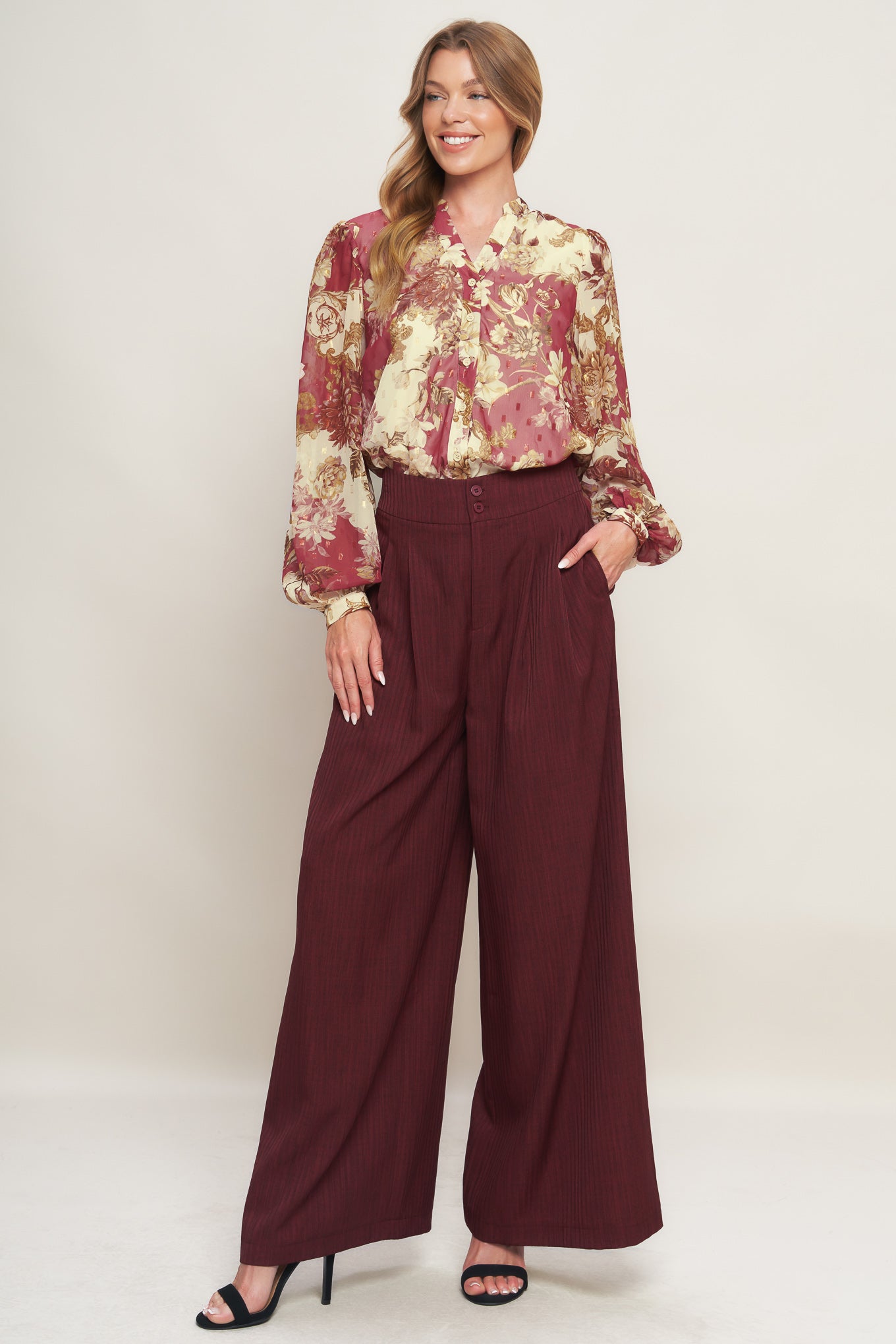 A printed woven top featuring round neckline with V front, long sleeve with cuff and button down closure