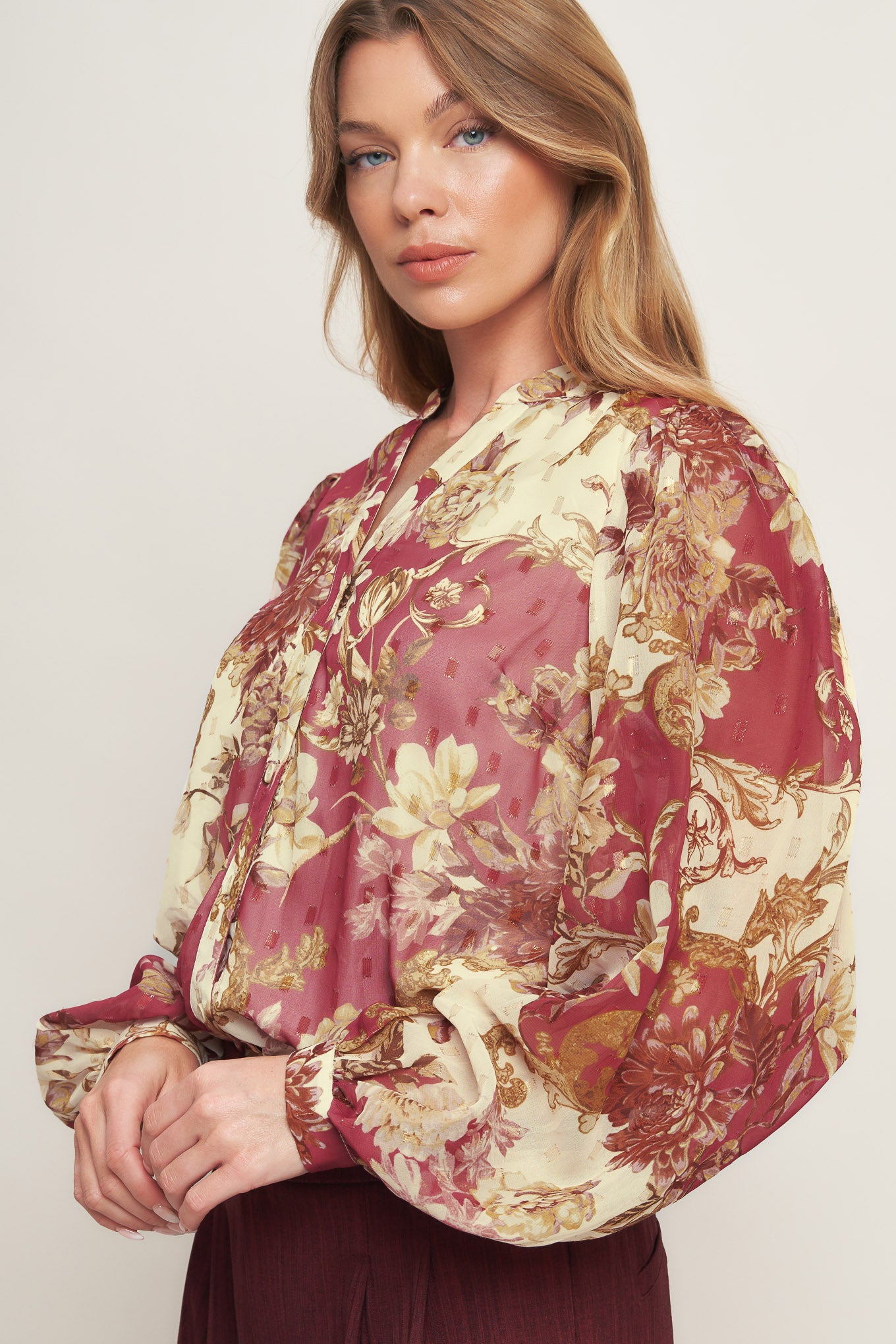 A printed woven top featuring round neckline with V front, long sleeve with cuff and button down closure