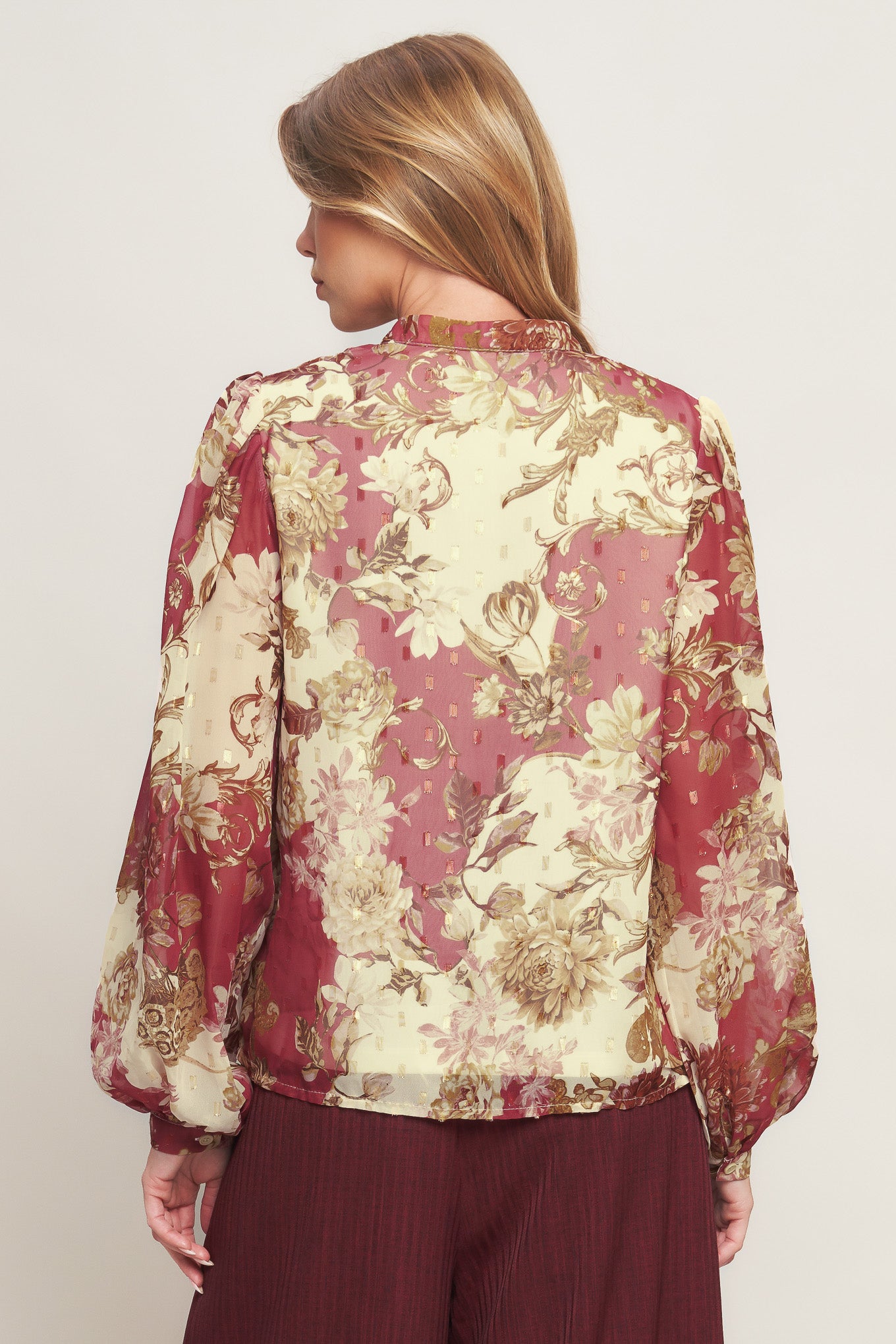 A printed woven top featuring round neckline with V front, long sleeve with cuff and button down closure