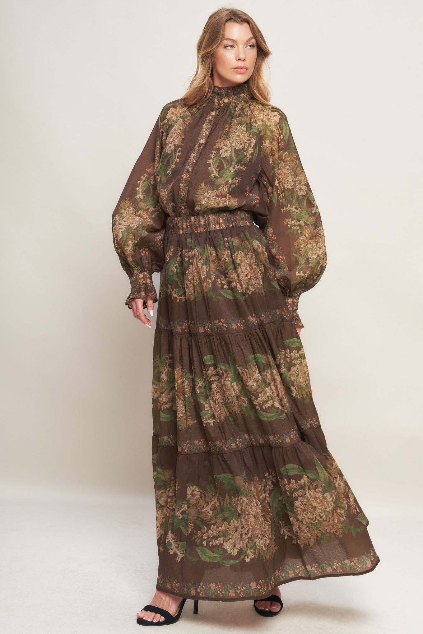 A printed woven top featuring ruffled high neckline, long sleeve with cuff and front button down closure