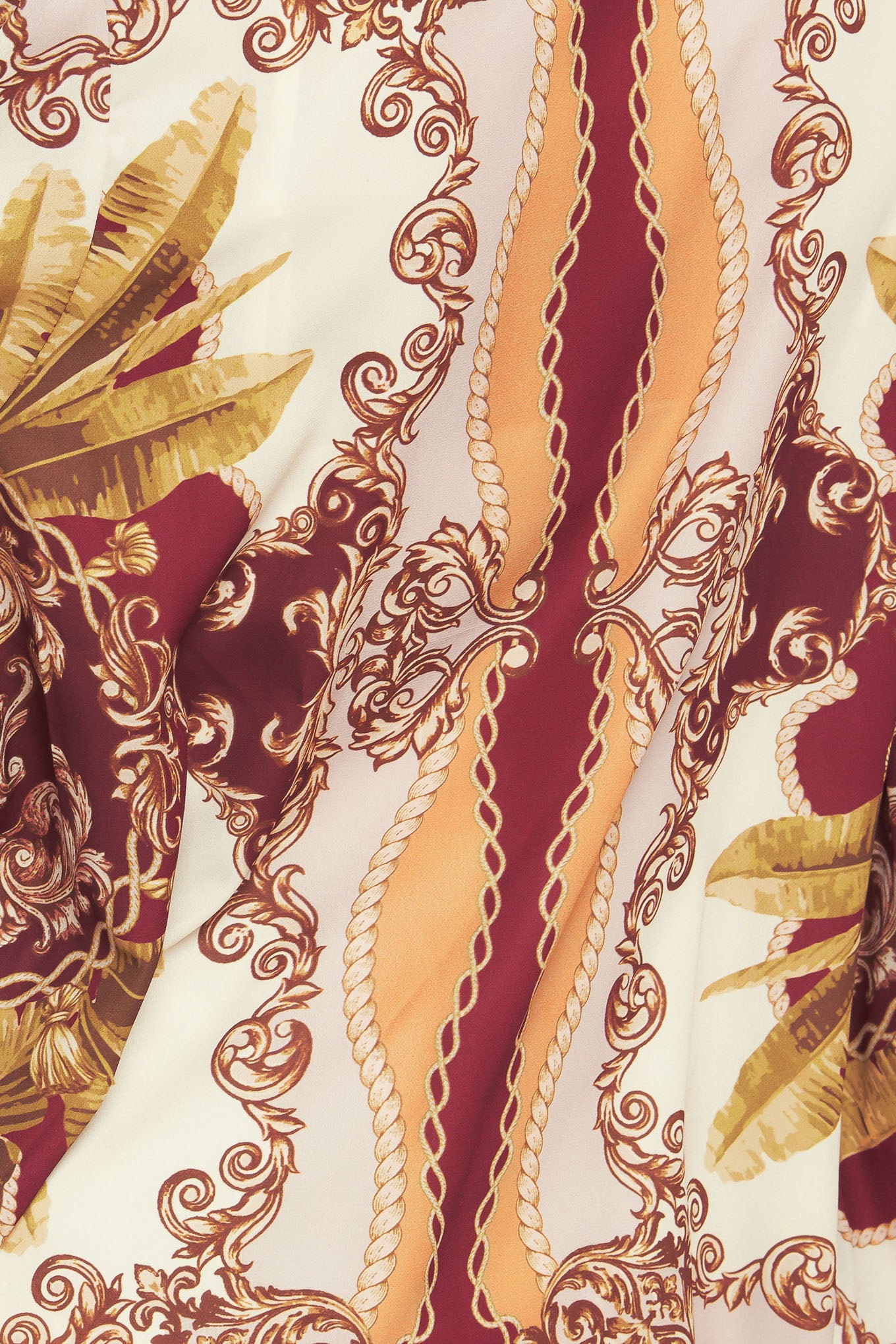 A printed woven top featuring front bow tie, long sleeve with smocked cuff and front button down closure