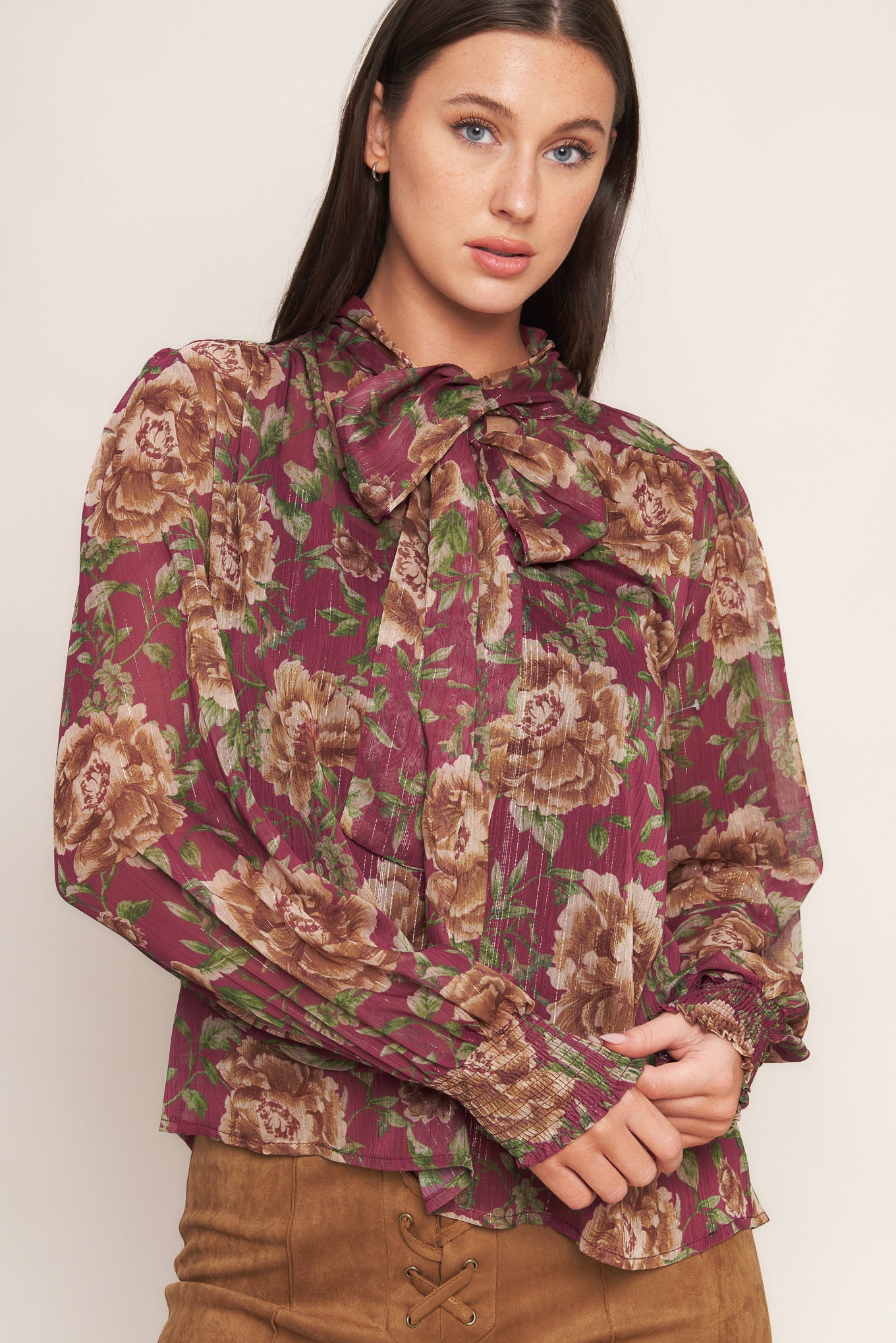 A printed woven top featuring front bow tie and long sleeve with smocked cuff