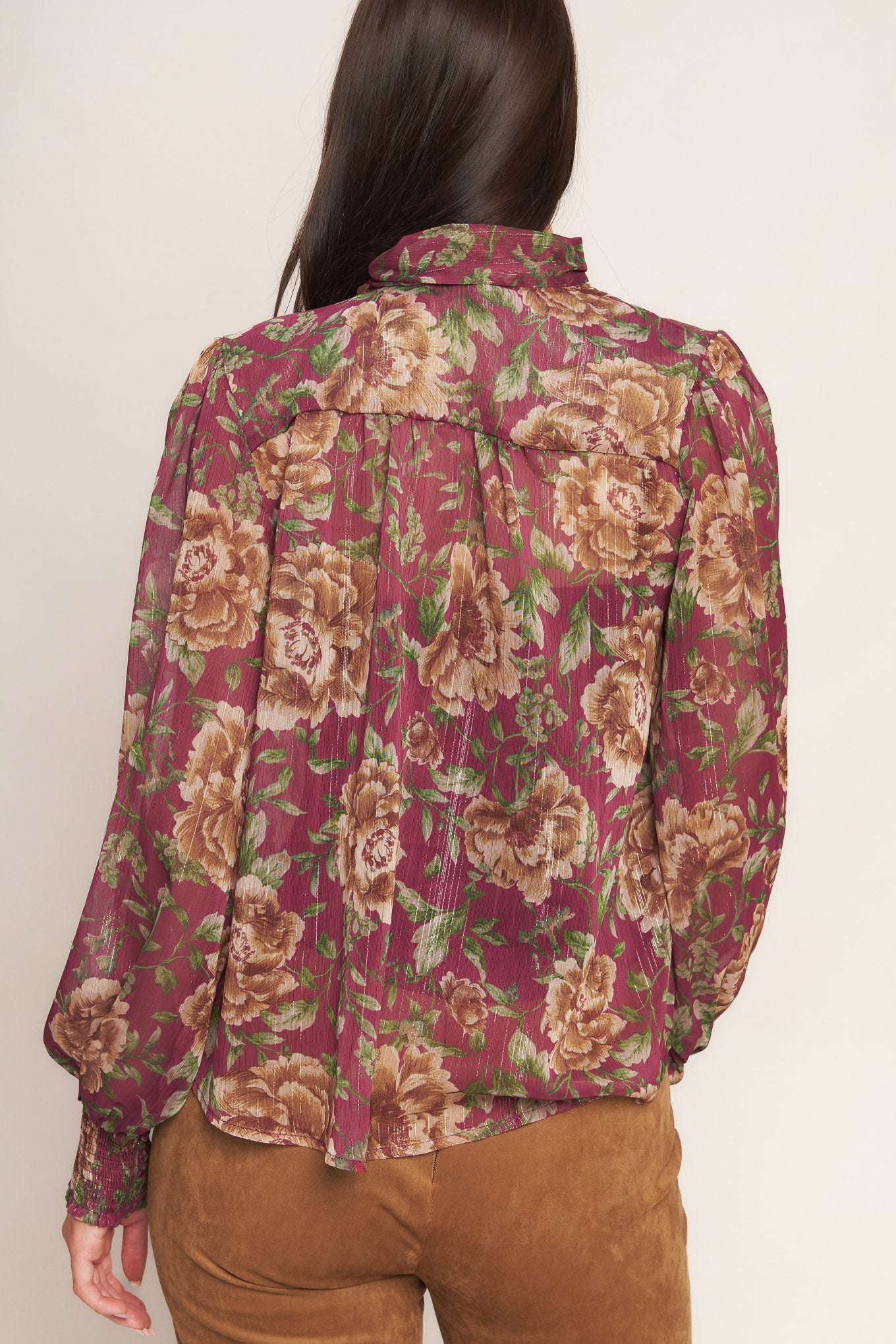 A printed woven top featuring front bow tie and long sleeve with smocked cuff