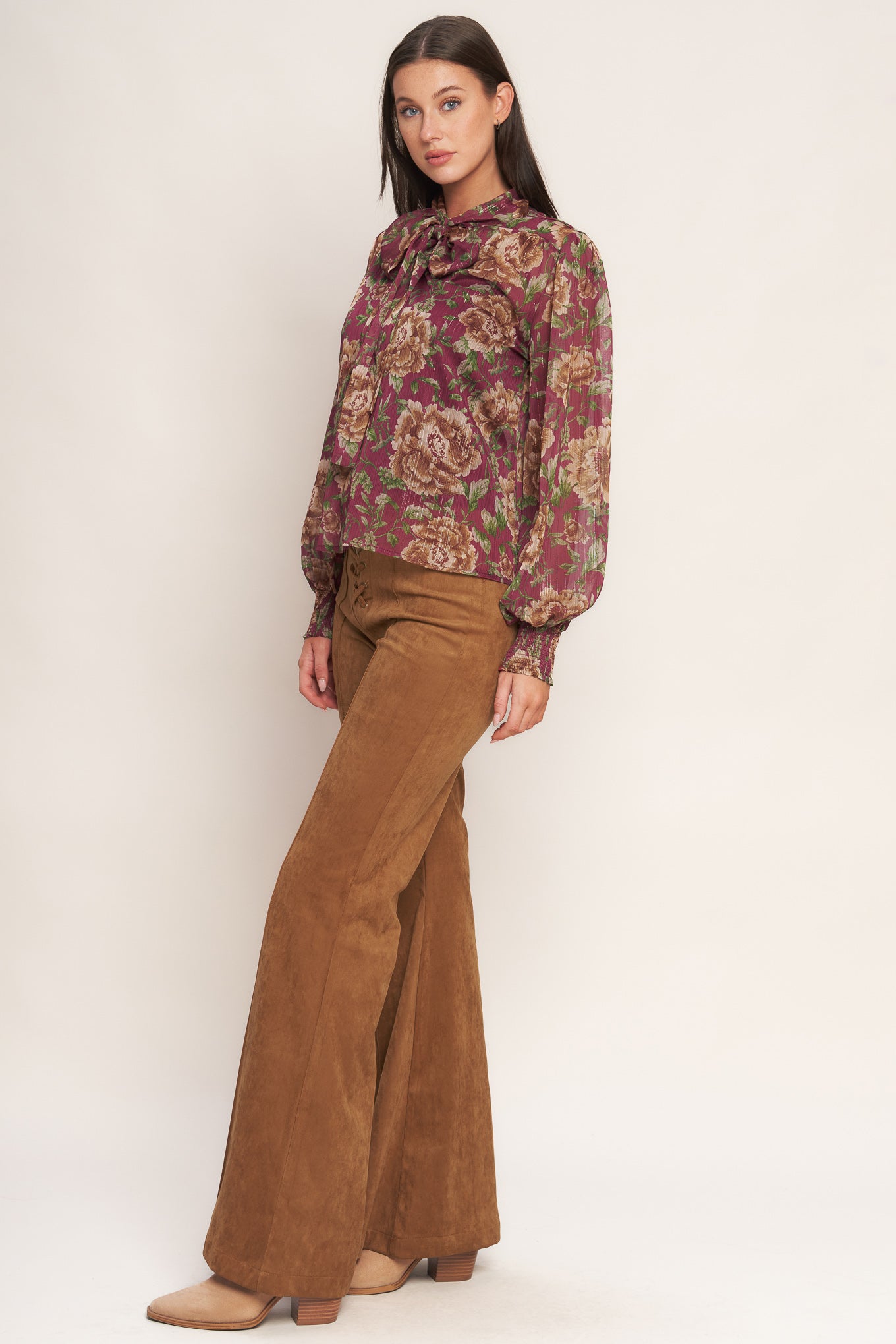 A printed woven top featuring front bow tie and long sleeve with smocked cuff