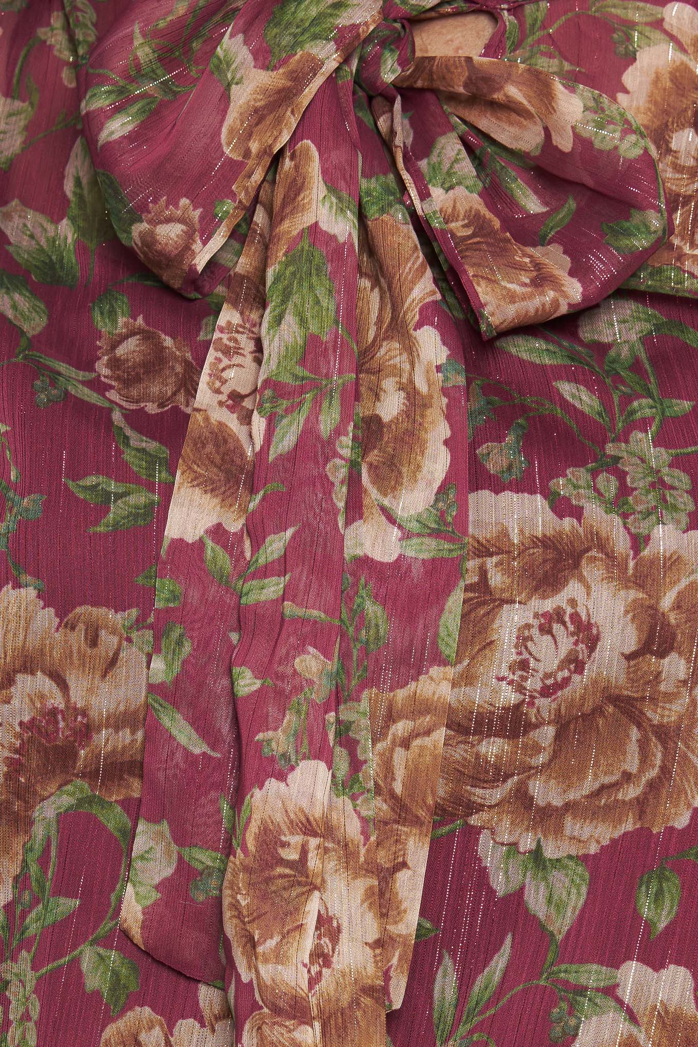 A printed woven top featuring front bow tie and long sleeve with smocked cuff