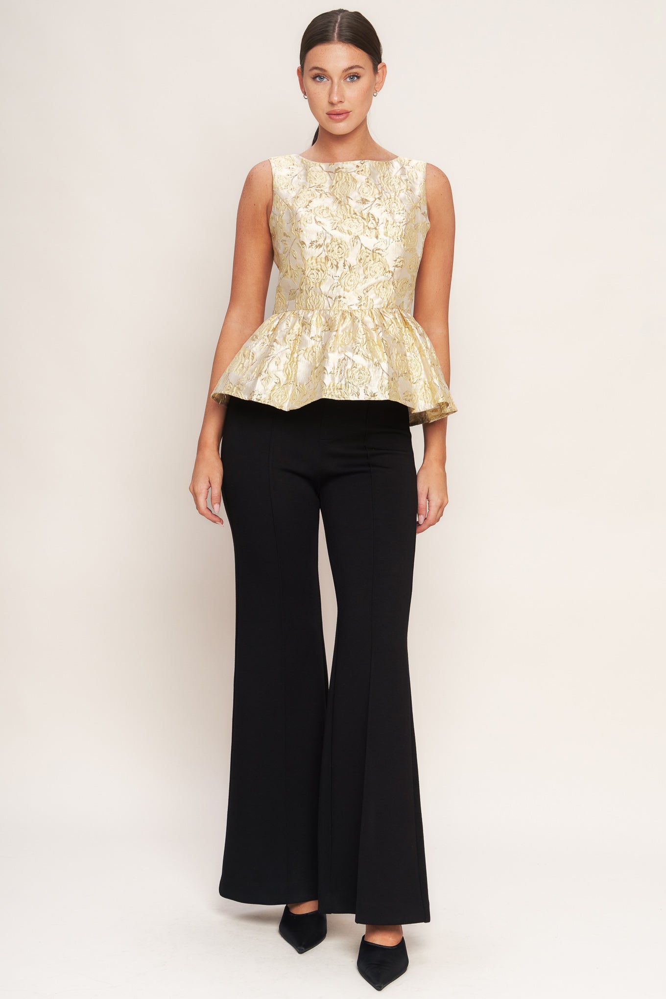 A metallic threaded jacquard woven top featuring wide neckline, peplum and back zipper closure