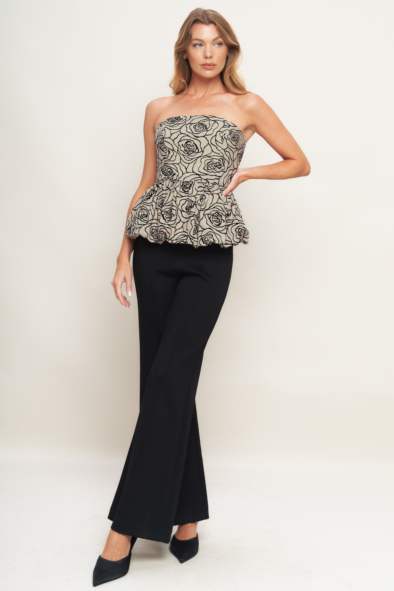 A textured woven top featuring strapless, bubble peplum and back zipper closure