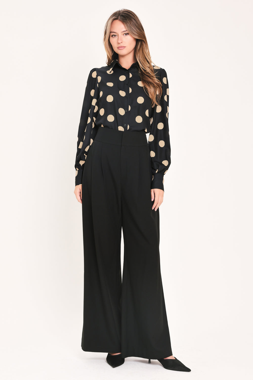 A woman wearing a polka dot printed woven top featuring collar, long sleeve with button down closure | Flying Tomato