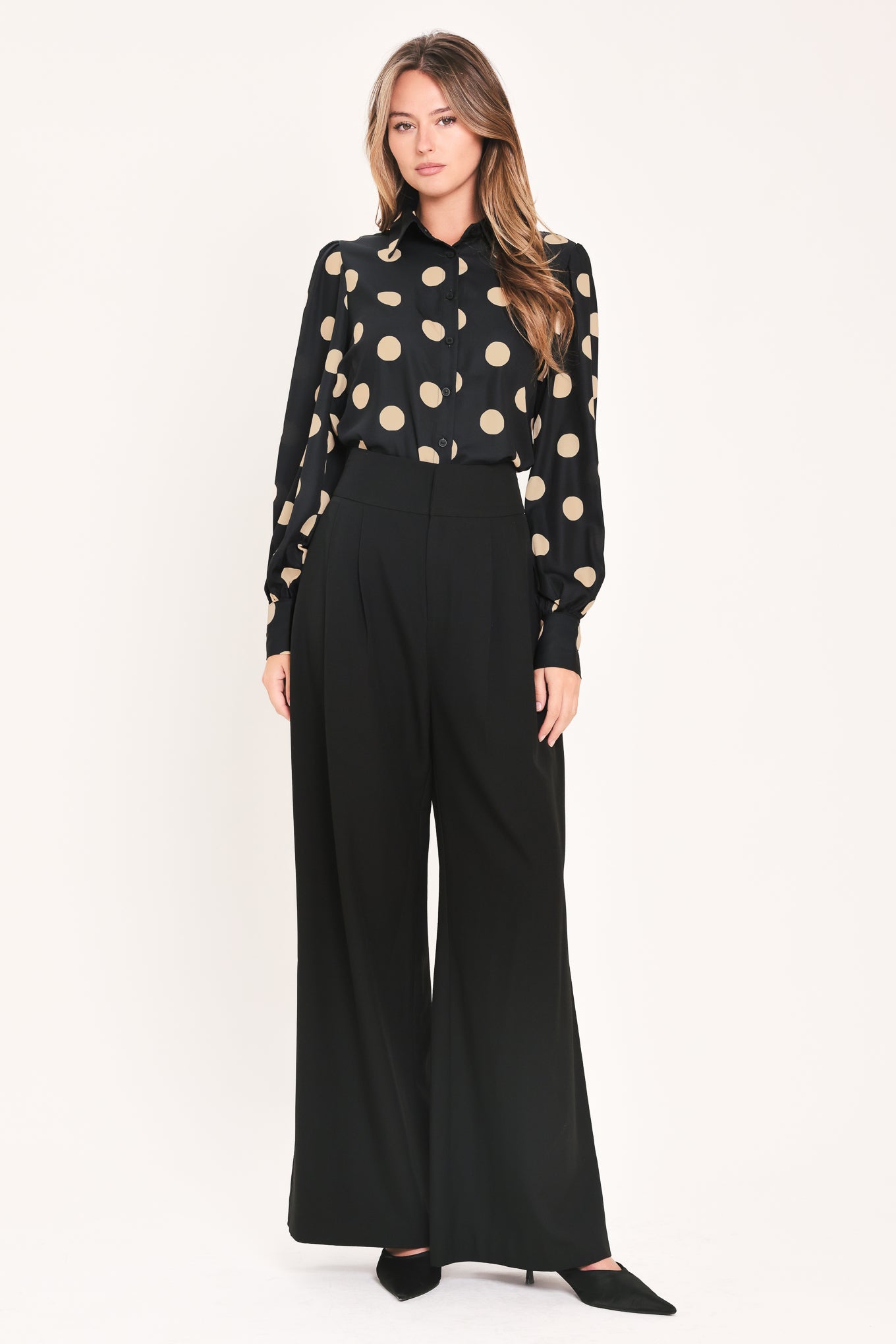A woman wearing a polka dot printed woven top featuring collar, long sleeve with button down closure | Flying Tomato