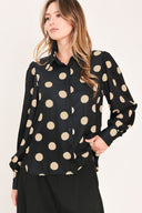 A woman wearing a polka dot printed woven top featuring collar, long sleeve with button down closure | Flying Tomato