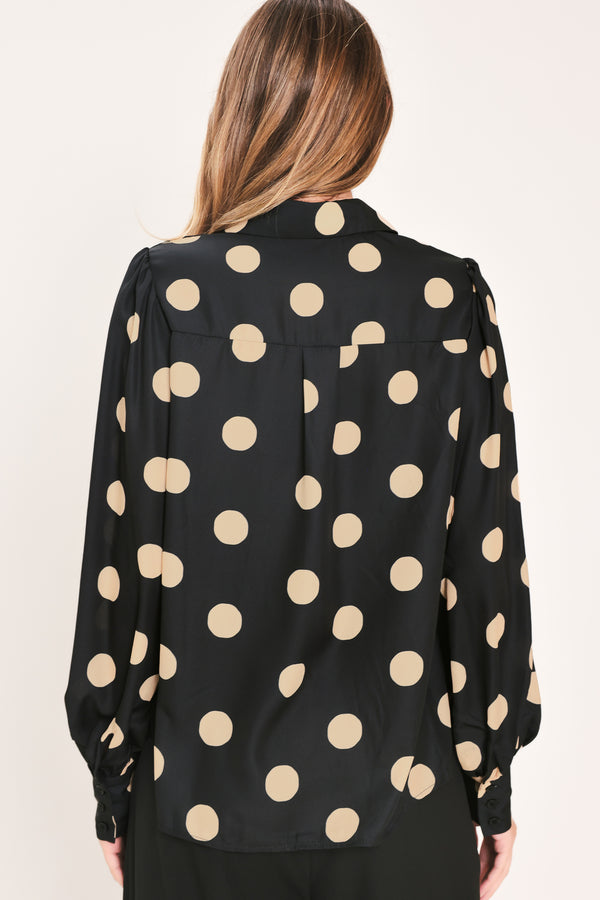 A woman wearing a polka dot printed woven top featuring collar, long sleeve with button down closure | Flying Tomato