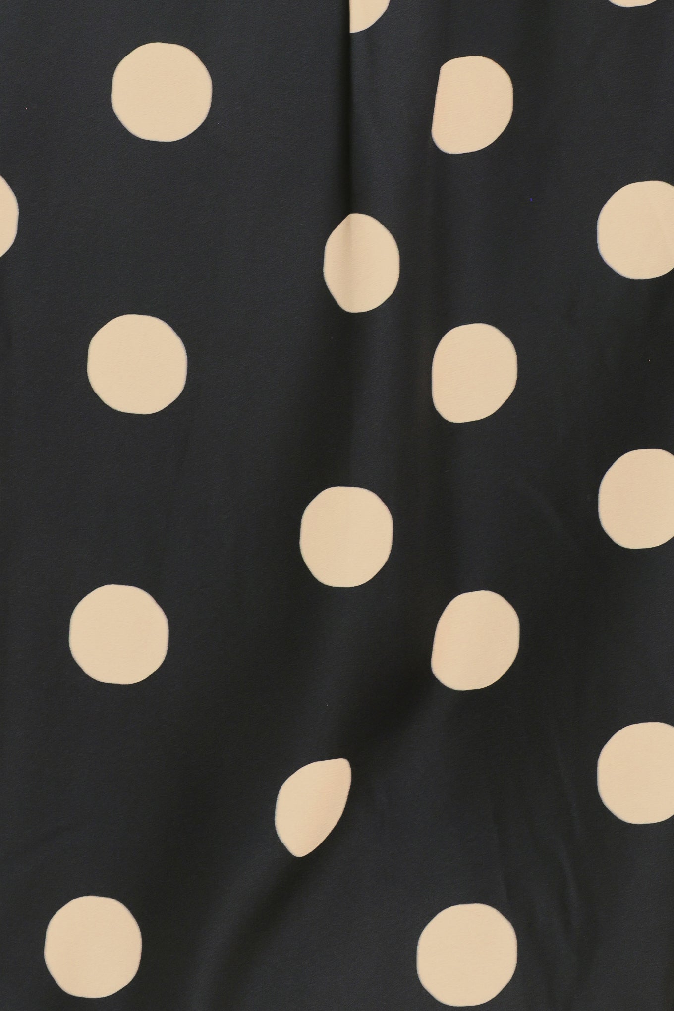 A woman wearing a polka dot printed woven top featuring collar, long sleeve with button down closure | Flying Tomato