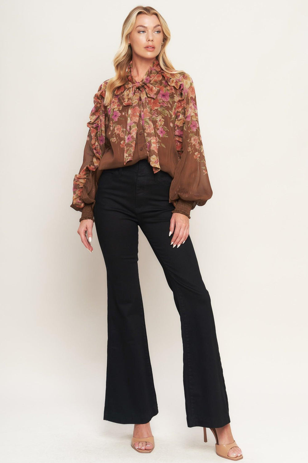 A printed woven top featuring front bow tie, long sleeve with smocked cuff and front button down closure