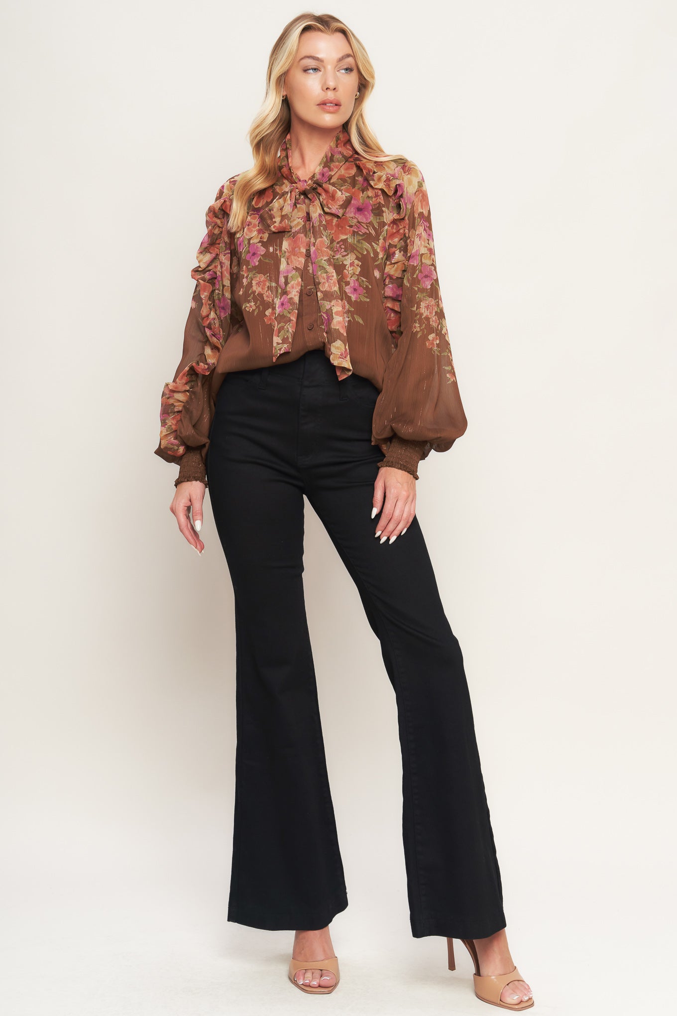 A printed woven top featuring front bow tie, long sleeve with smocked cuff and front button down closure