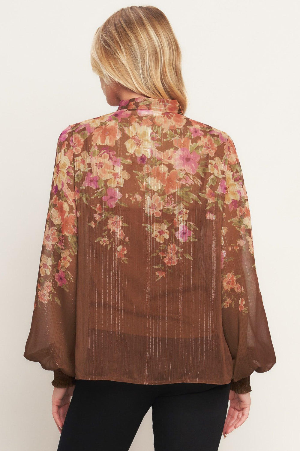 A printed woven top featuring front bow tie, long sleeve with smocked cuff and front button down closure