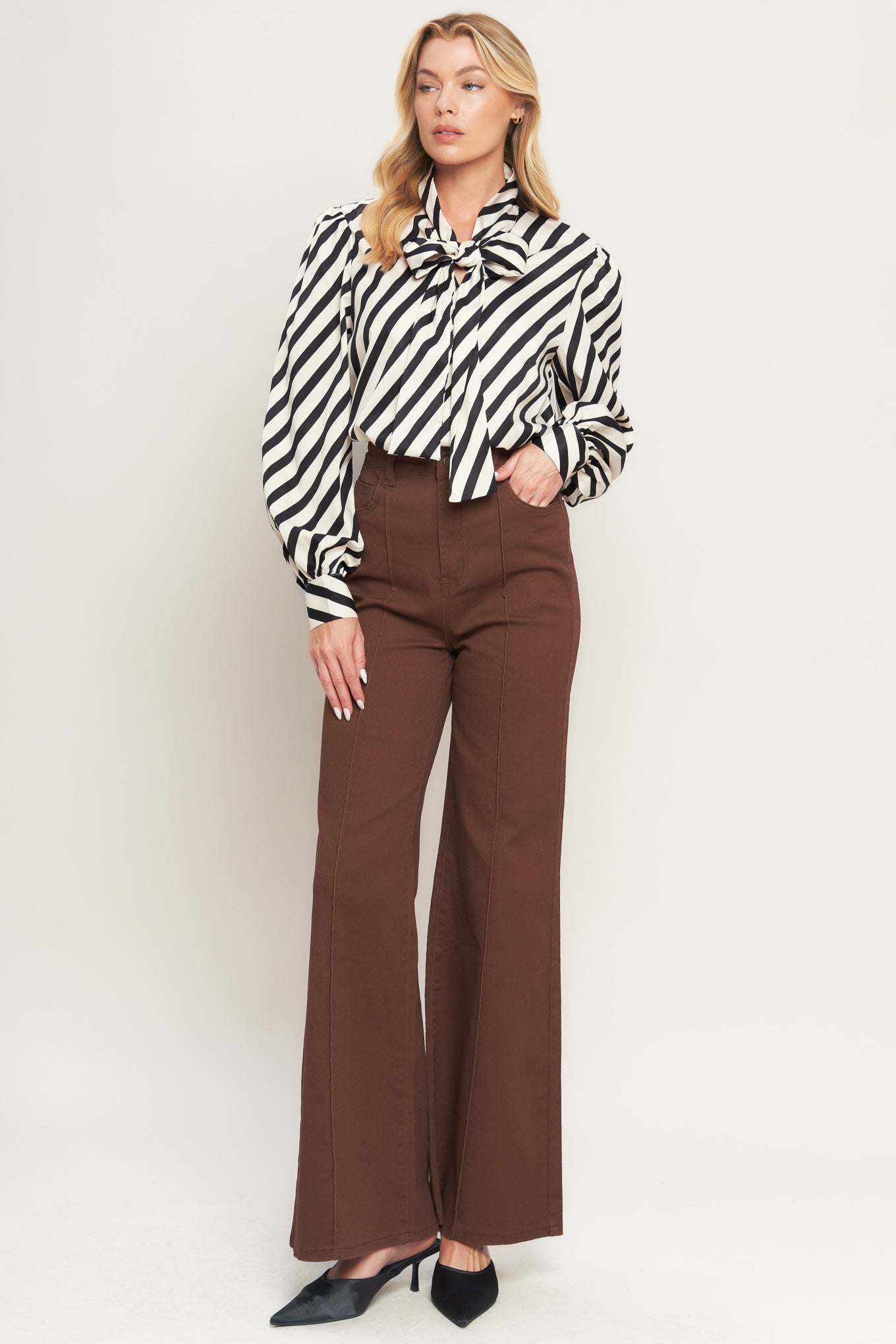 A striped woven top featuring high neckline with front bow tie and long sleeve with cuff