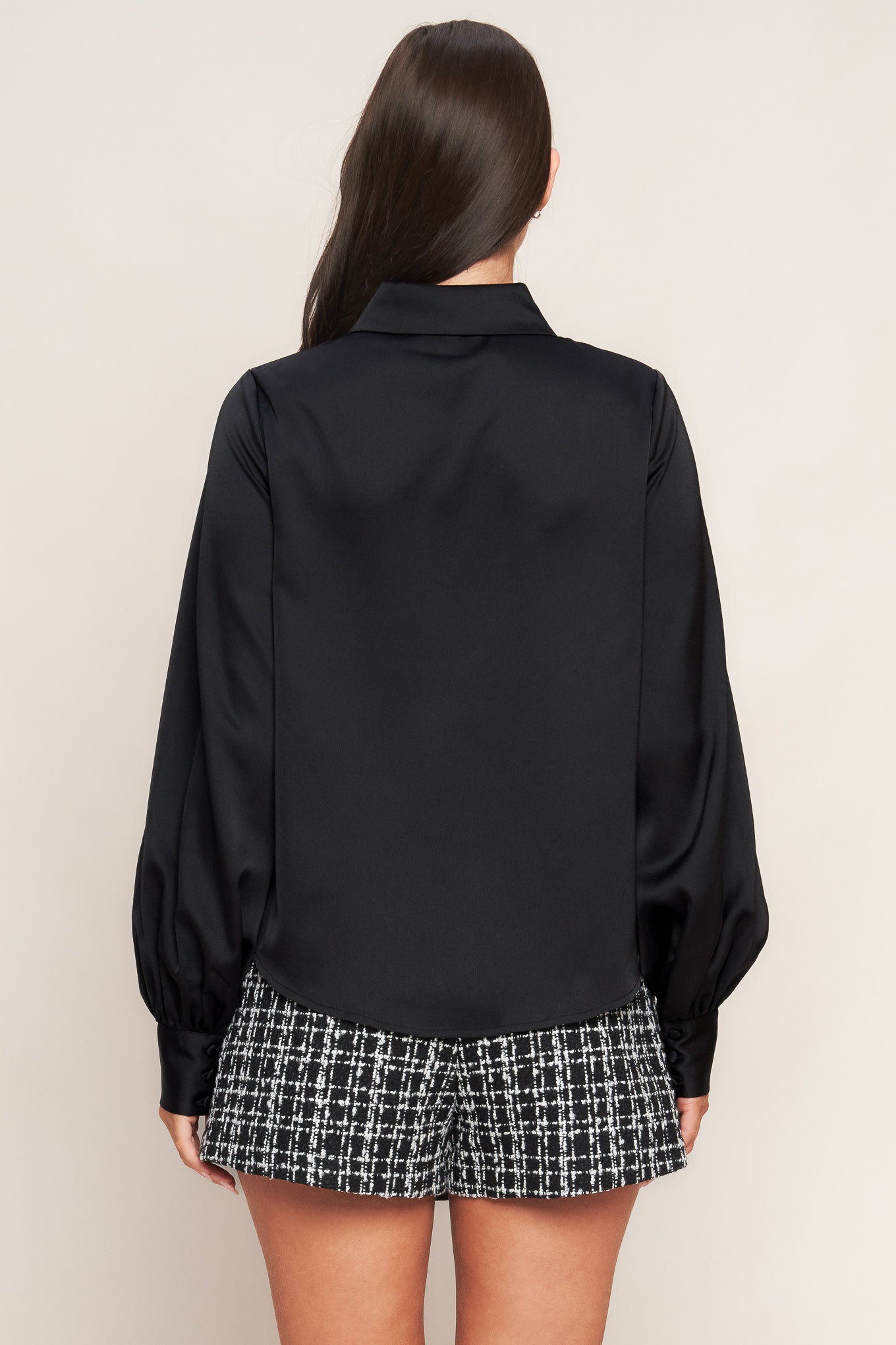 A solid woven top featuring collar, button down and long blouson sleeve with cuff