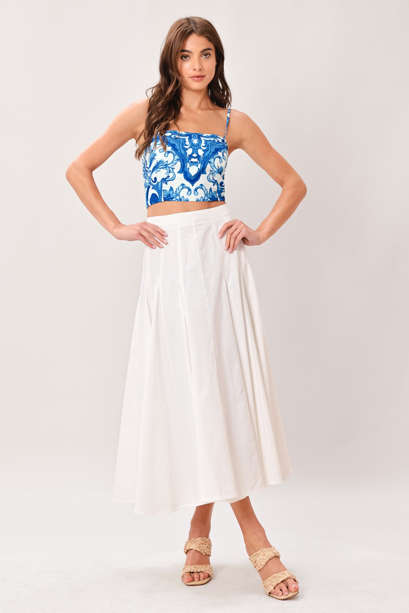 Woman wearing a blue and white patterned crop top featuring straight neckline, straps and smocked back bodice | Flying Tomato