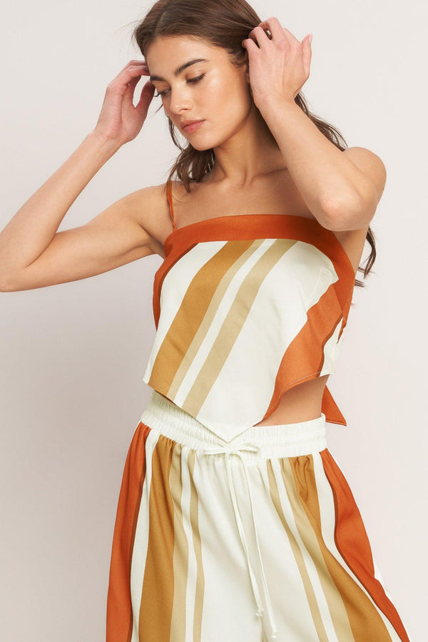 A printed woven scarf top featuring straight neckline, straps and tie back. 