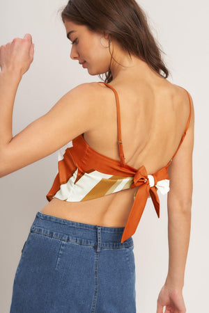 A printed woven scarf top featuring straight neckline, straps and tie back. 