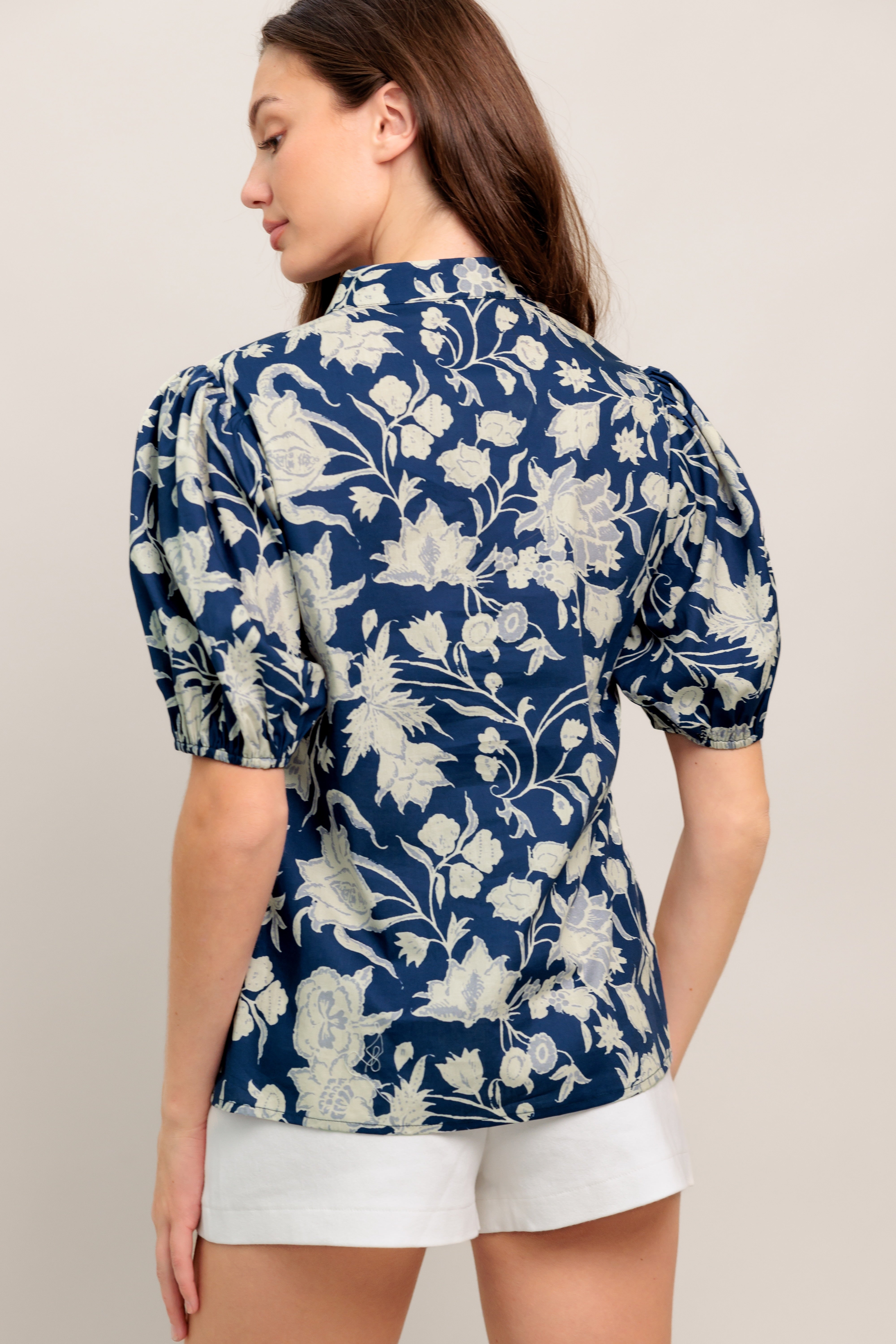 Navy floral V-neck blouse with soft puff sleeves and a relaxed, polished fit

Details:

Self: 100% Cotton

Size & Fit

- Model is 5`8" And Wearing Size Small
- Measurements Taken From Size Small
- Approx. Length: 24"