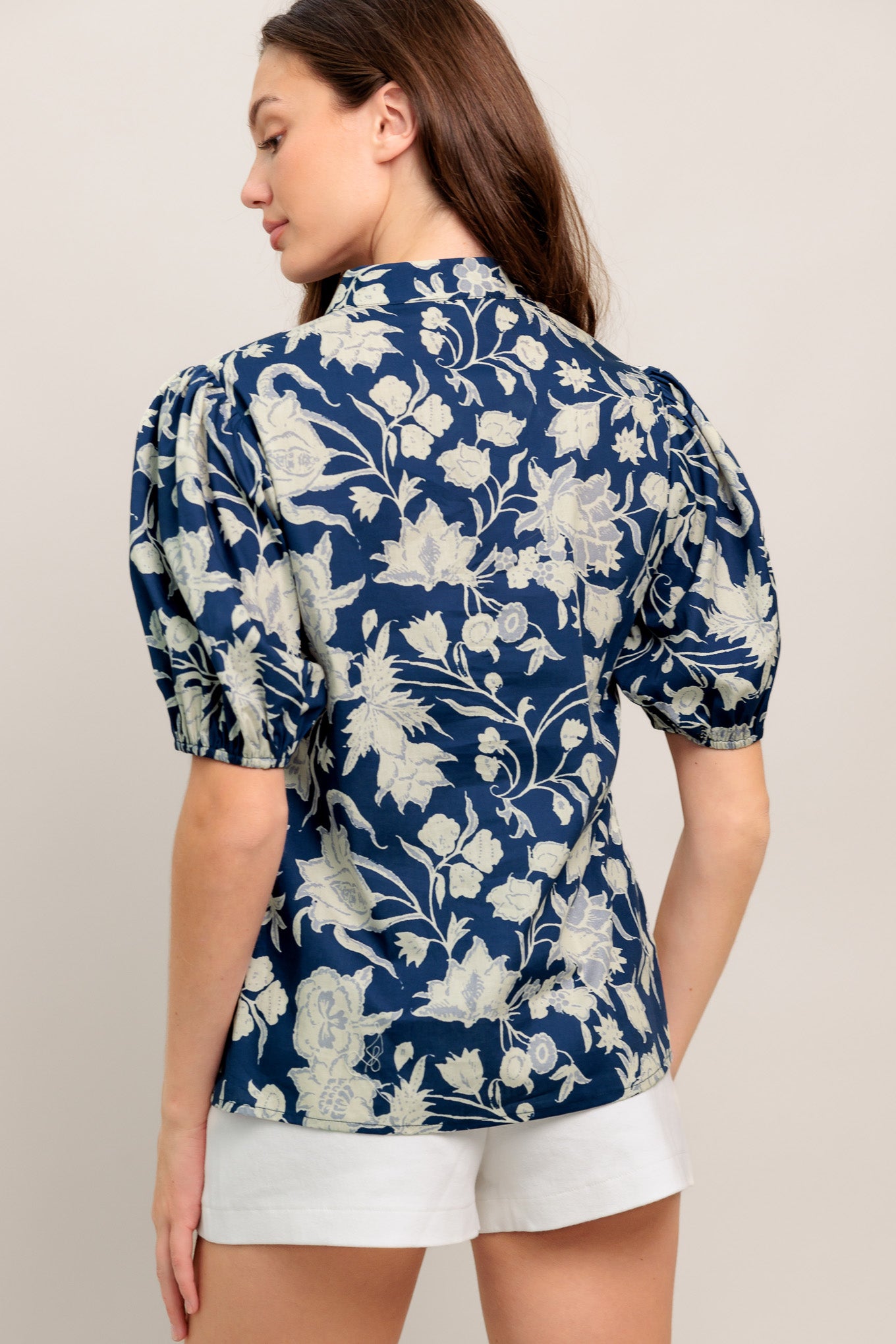 Navy floral V-neck blouse with soft puff sleeves and a relaxed, polished fit

Details:

Self: 100% Cotton

Size & Fit

- Model is 5`8" And Wearing Size Small
- Measurements Taken From Size Small
- Approx. Length: 24"