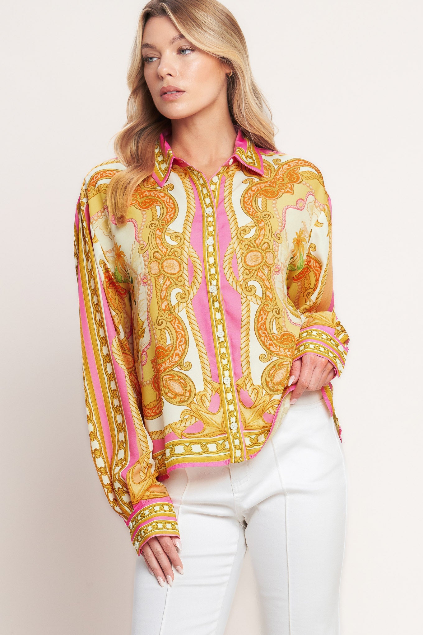 Woman wearing a colorful patterned blouse with a plain background