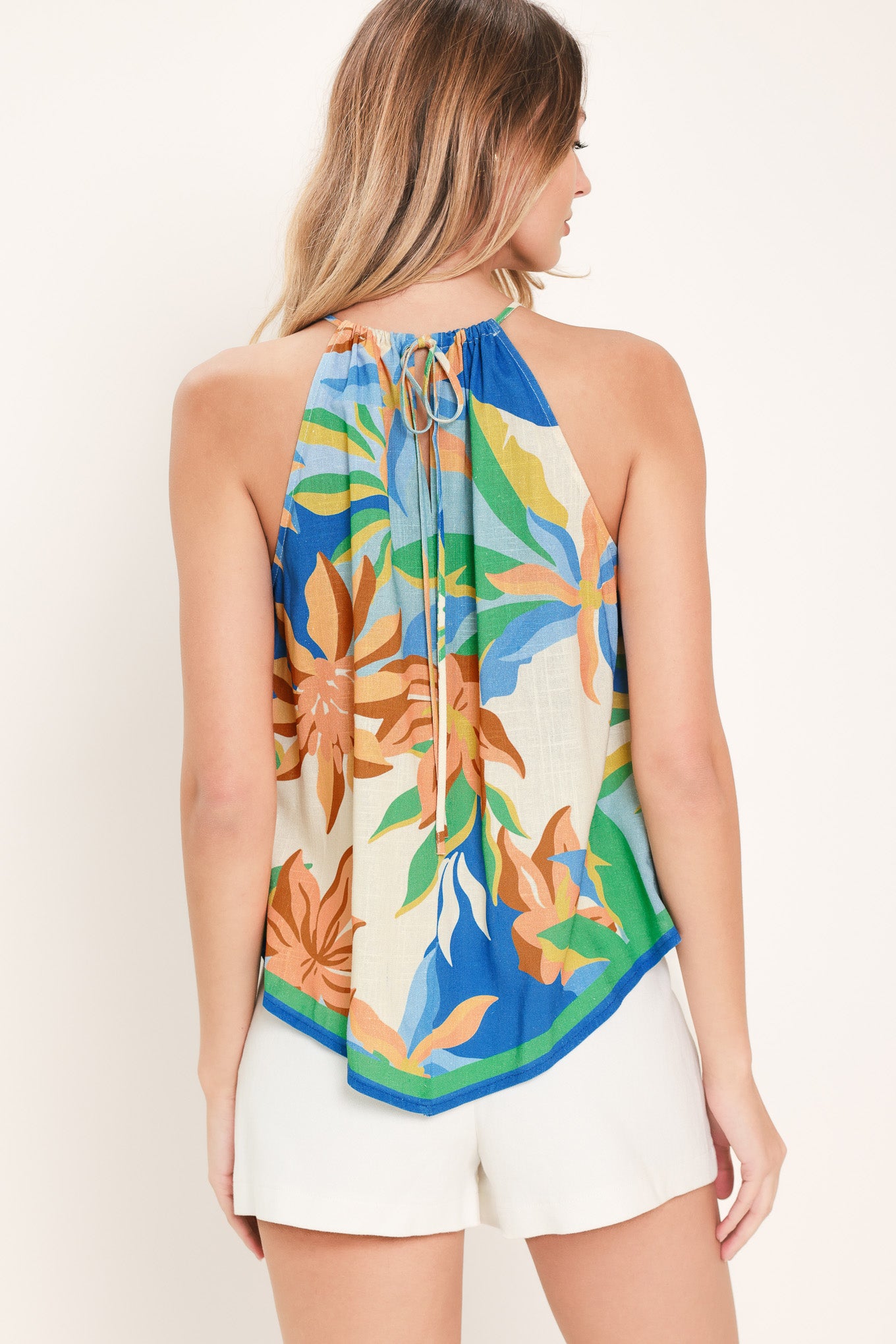 Woman wearing a woven scarf top with halter neckline and back neck tie | Flying Tomato