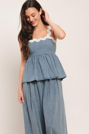 A lightweight washed denim top featuring straight neckline with ric-rac trim, ric-rac straps, peplum and smocked back bodice. Matching pant IP9110T

Details:

Self: 100% Cotton Exclusive of Decoration

Size & Fit

-Model is 5`8" And Wearing Size Small
-Measurements Taken From Size Small
-Approx. Length: 23"