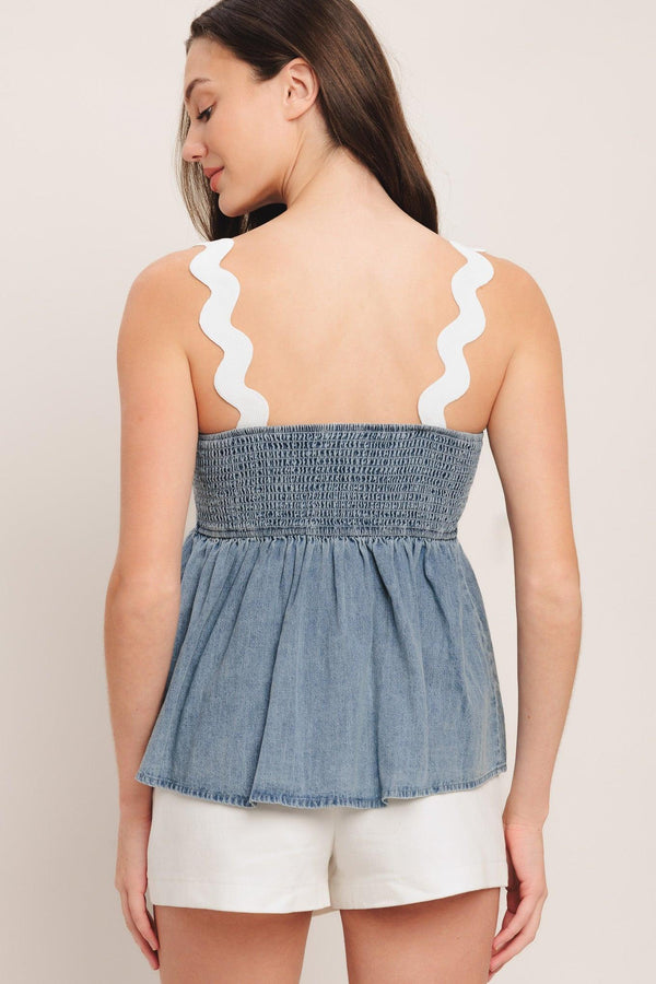 A lightweight washed denim top featuring straight neckline with ric-rac trim, ric-rac straps, peplum and smocked back bodice. Matching pant IP9110T

Details:

Self: 100% Cotton Exclusive of Decoration

Size & Fit

-Model is 5`8" And Wearing Size Small
-Measurements Taken From Size Small
-Approx. Length: 23"