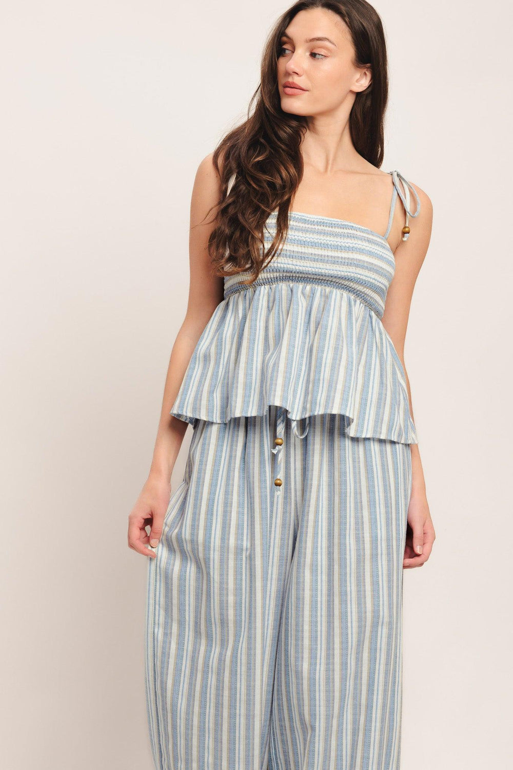 A striped woven top featuring straight neckline, shoulder tie and smocked bodice. Matching pant IP9116T

Details:

Self: 60% Polyester 20% Cotton 20% Linen

Size & Fit

-Model is 5`8" And Wearing Size Small
-Measurements Taken From Size Small
-Approx. Length: 21"