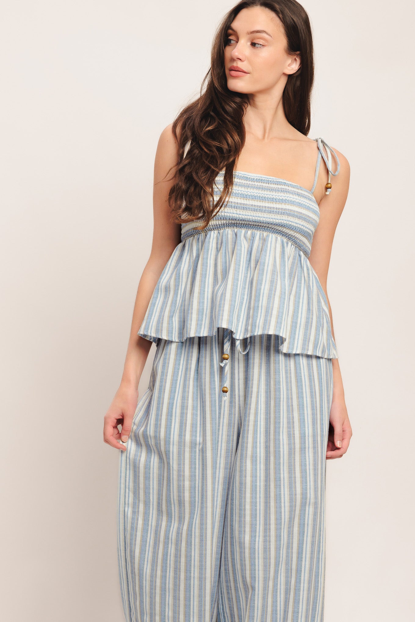 A striped woven top featuring straight neckline, shoulder tie and smocked bodice. Matching pant IP9116T

Details:

Self: 60% Polyester 20% Cotton 20% Linen

Size & Fit

-Model is 5`8" And Wearing Size Small
-Measurements Taken From Size Small
-Approx. Length: 21"