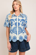Woman wearing a short sleeve blue and white patterned shirt top with front scallop hem | Flying Tomato