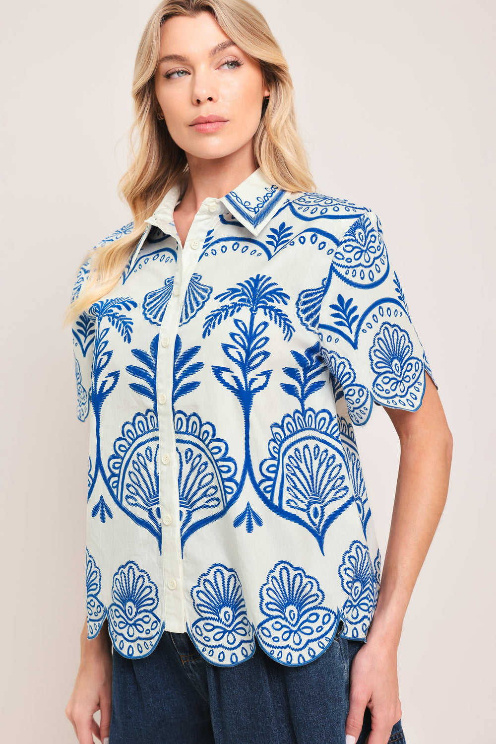 Woman wearing a short sleeve blue and white patterned shirt top with front scallop hem | Flying Tomato