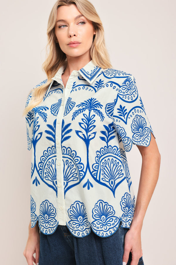 Woman wearing a short sleeve blue and white patterned shirt top with front scallop hem | Flying Tomato