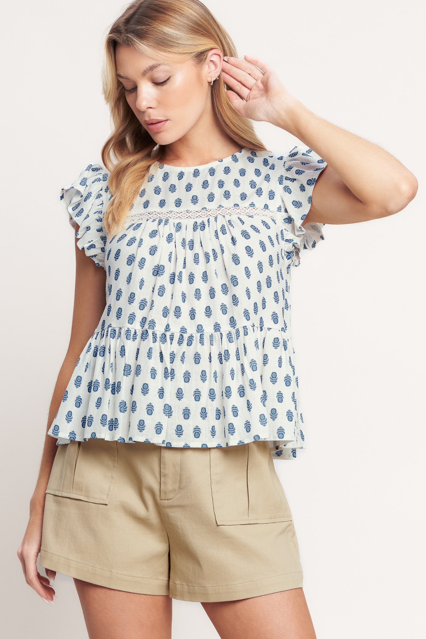 A printed woven top featuring round neckline, ruffle sleeve, lace inset and back neck button closure

Details:

Self: 70% Rayon 30% Linen

Size & Fit

- Model is 5`8" And Wearing Size Small
- Measurements Taken From Size Small
- Approx. Length: 23"