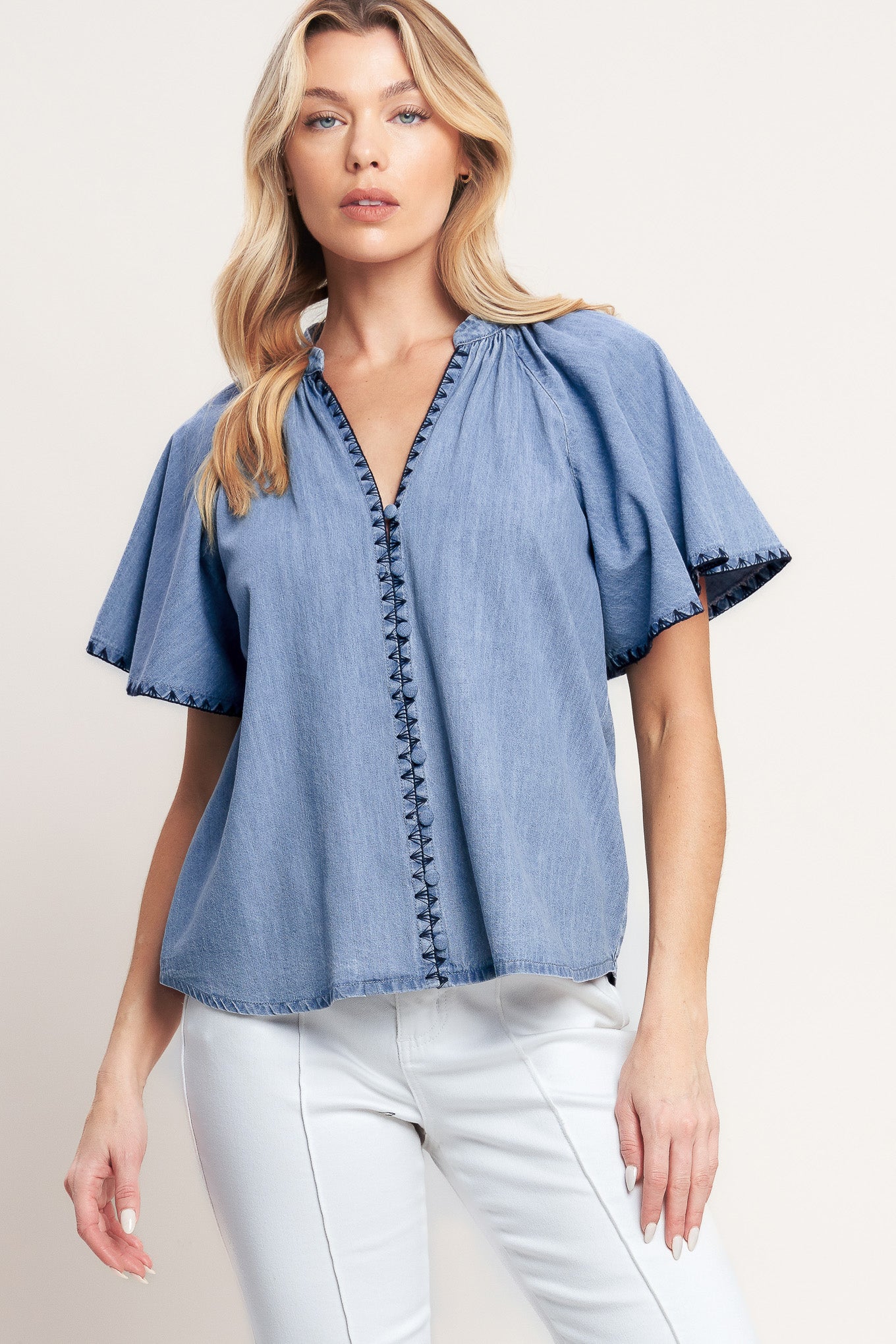 A solid woven top featuring V neckline, short flutter sleeve, button down and stitched edge

Details:

Self: 90% Cotton 10% Polyester

Size & Fit

-Model is 5`8" And Wearing Size Small
-Measurements Taken From Size Small
-Approx. Length: 25"