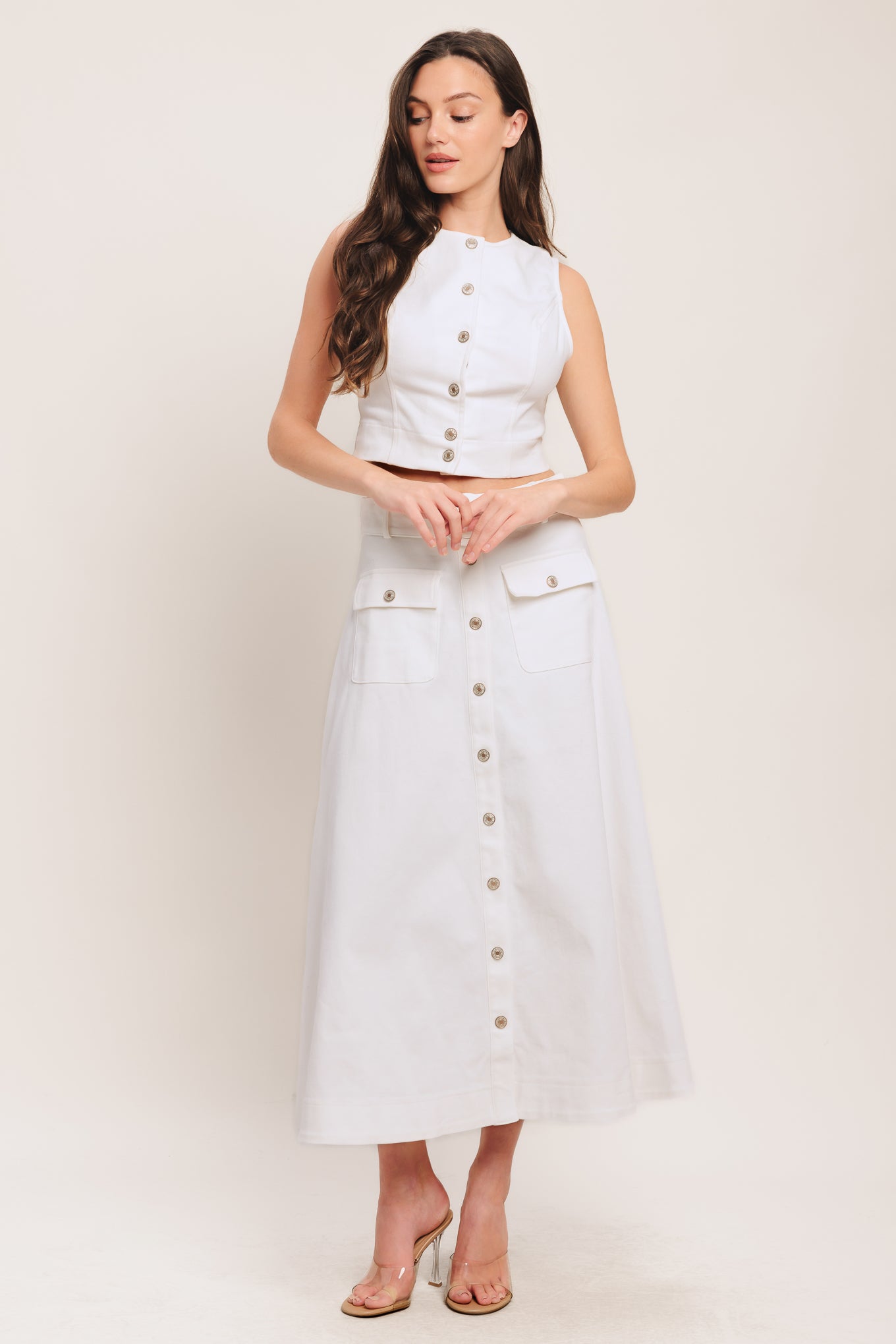 A solid woven crop top featuring round neckline, sleeveless and front button down closure. Matching skirt IK7784T

Details:

Self: 97% Cotton 3% Spandex

Size & Fit

-Model is 58 And Wearing Size Small
-Measurements Taken From Size Small
-Approx. Length: 20"