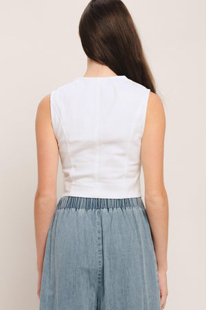 A solid woven crop top featuring round neckline, sleeveless and front button down closure. Matching skirt IK7784T

Details:

Self: 97% Cotton 3% Spandex

Size & Fit

-Model is 58 And Wearing Size Small
-Measurements Taken From Size Small
-Approx. Length: 20"