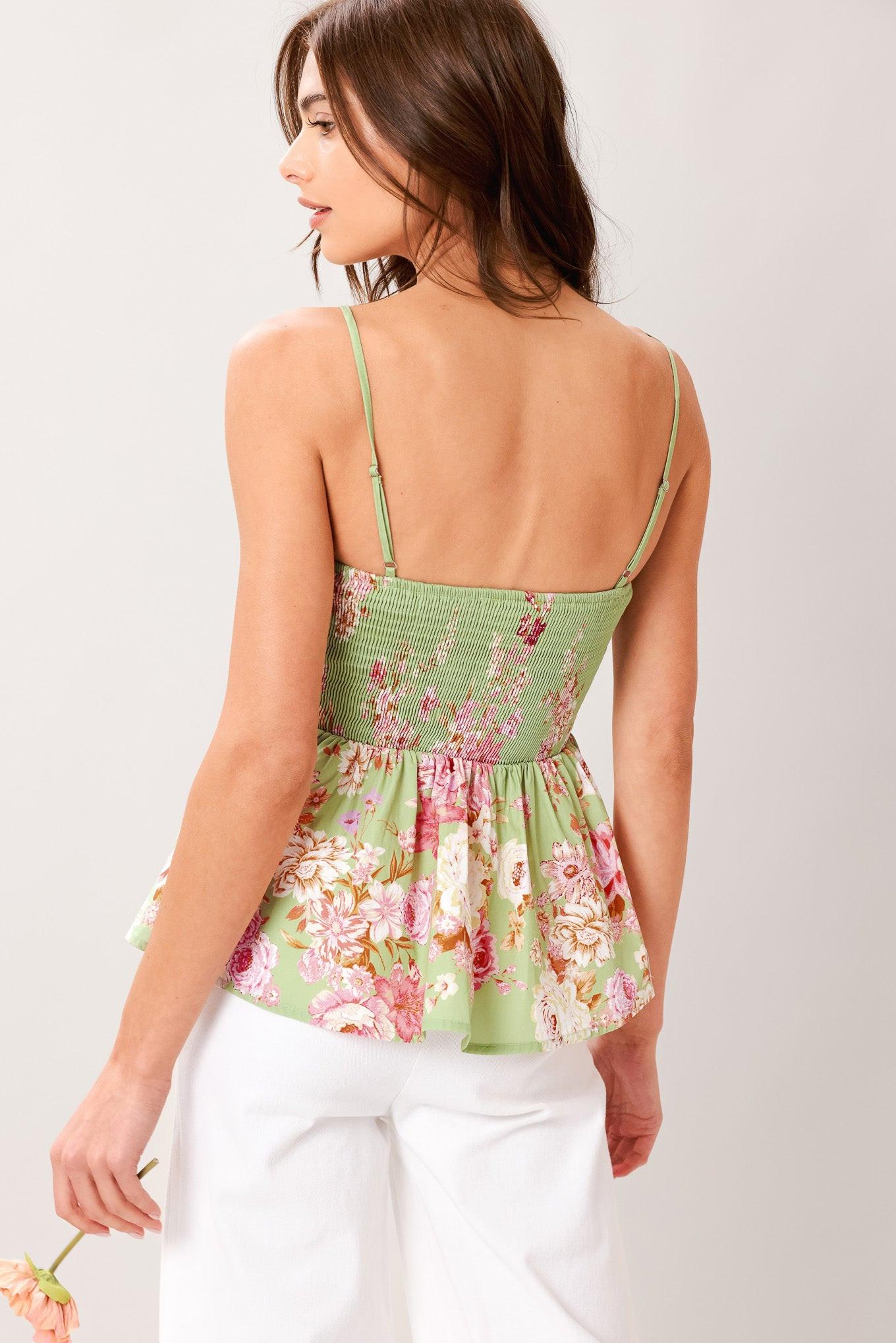 A printed woven top with straight neckline, straps, peplum and smocked back bodice