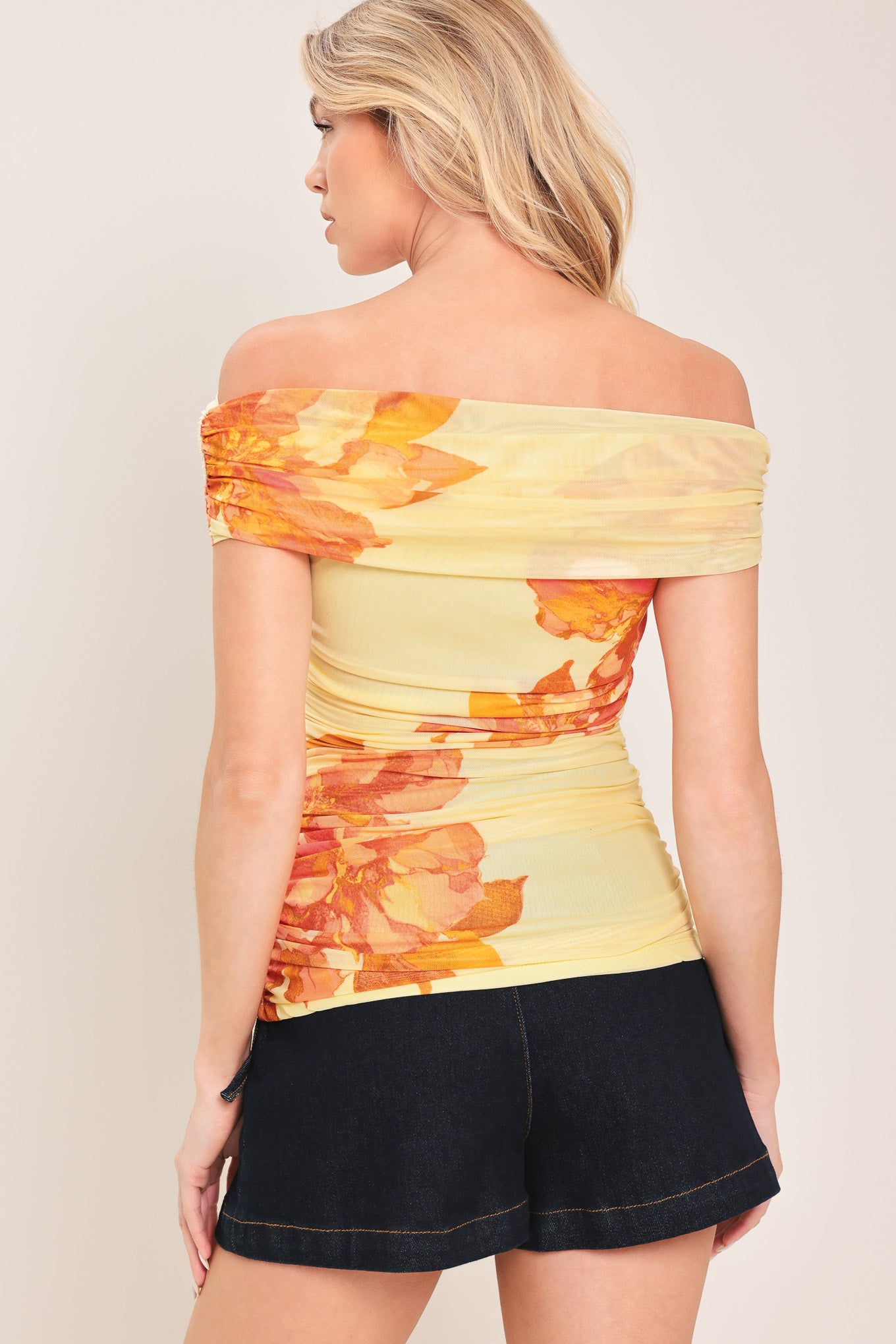 Woman wearing a yellow and orange floral off-shoulder power mesh top | Flying Tomato