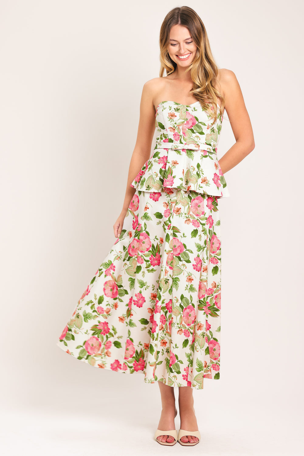 Woman wearing a floral strapless tube top with sweetheart neckline, peplum and back zipper closure | Flying Tomato