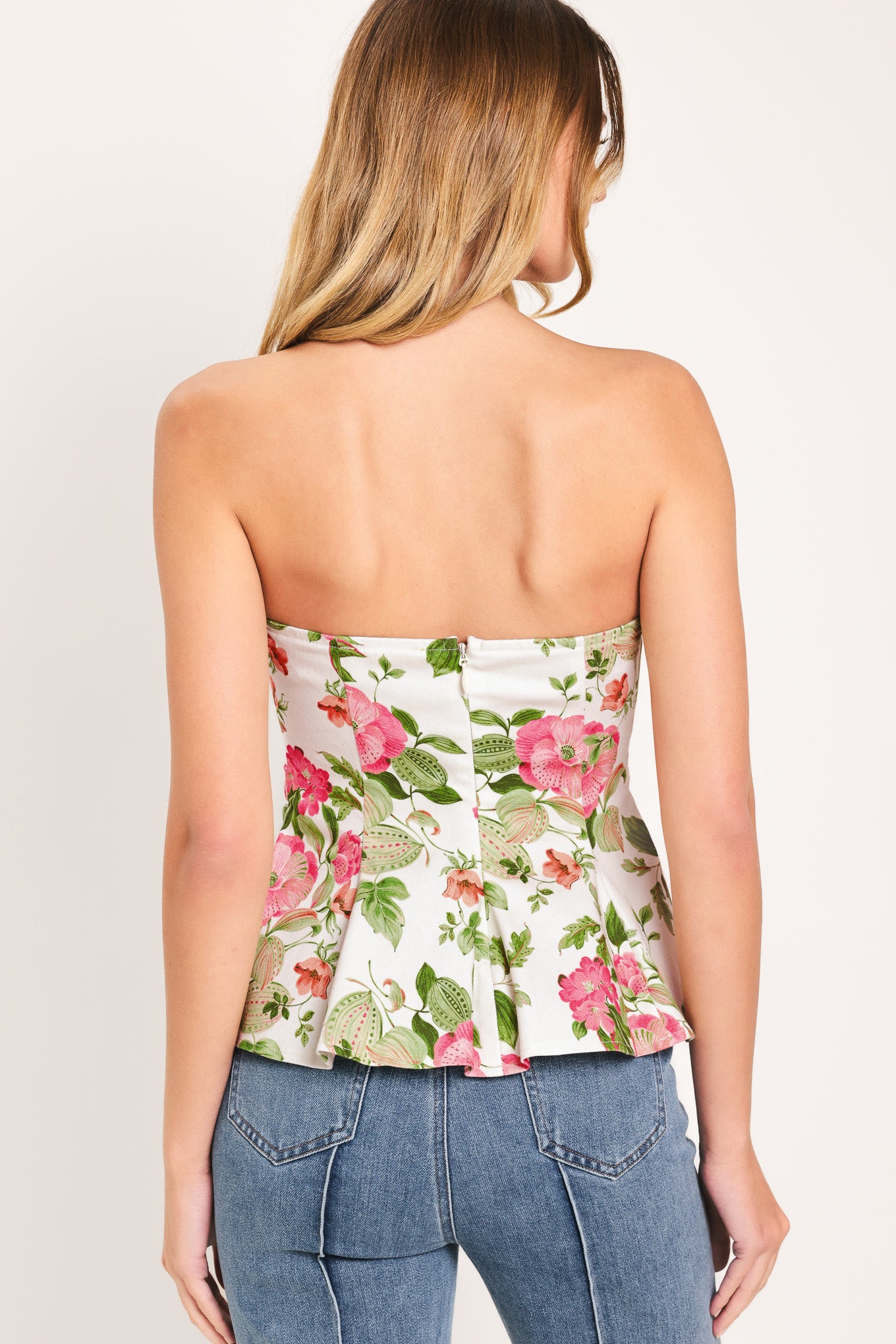 Woman wearing a floral strapless tube top with sweetheart neckline, peplum and back zipper closure | Flying Tomato