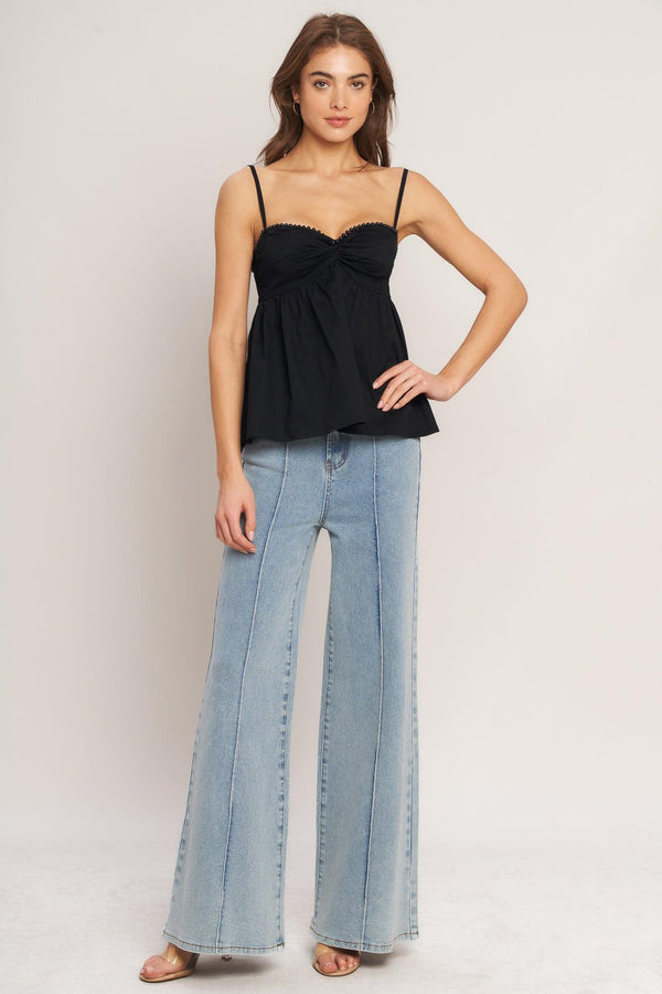 A black solid woven top featuring twisted bodice with bead trim, straps and back zipper closure