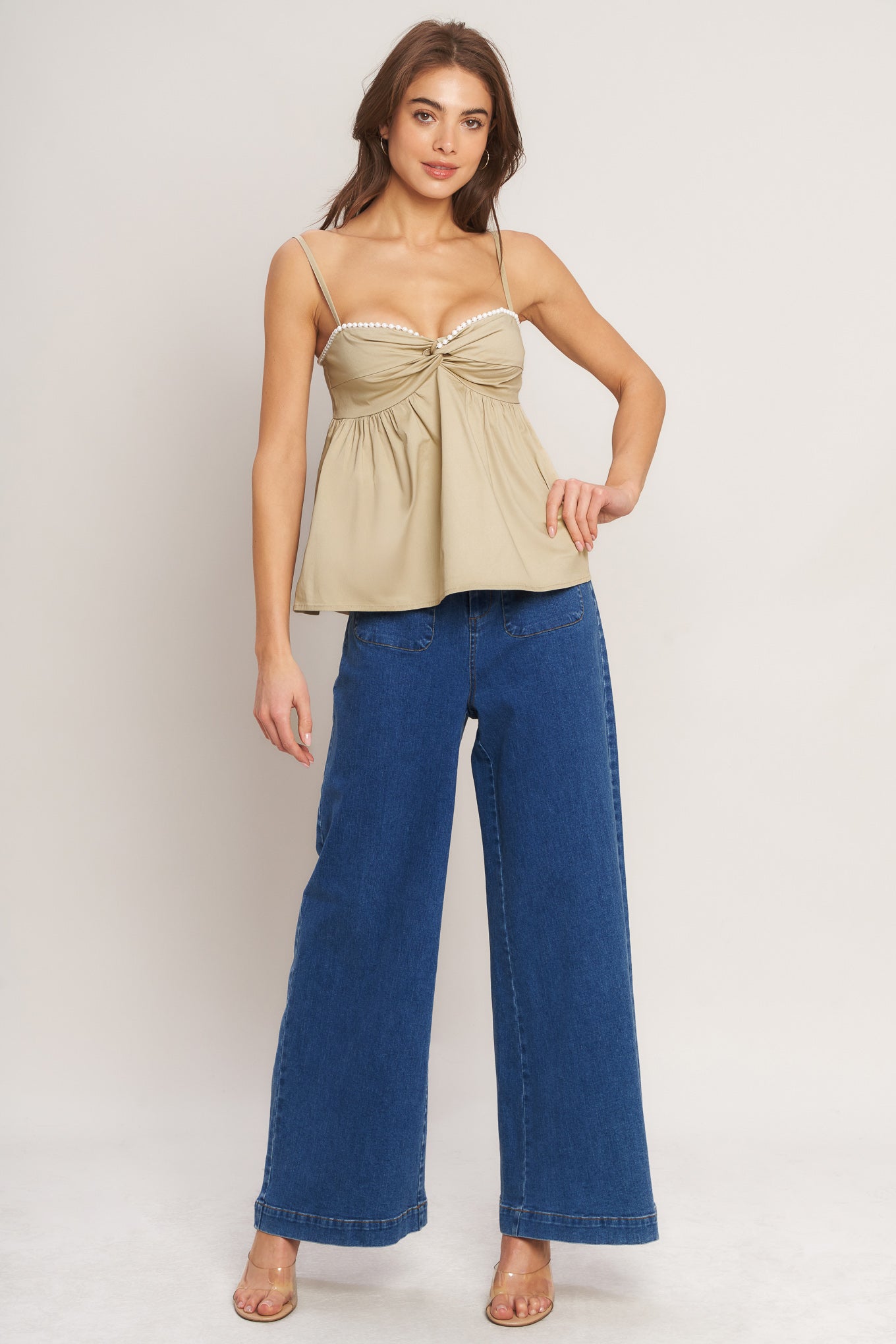 A taupe solid woven top featuring twisted bodice with bead trim, straps and back zipper closure